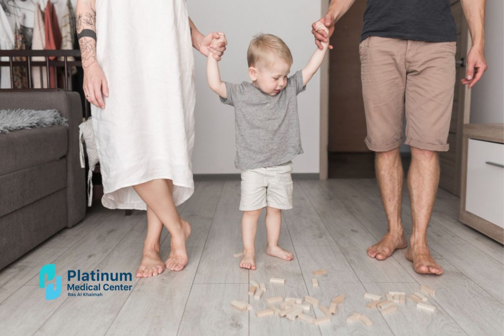 Toddler learning to walk with parental support showing healthy child growth and development milestones in early childhood